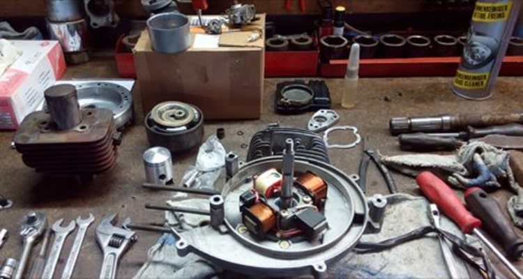 Een brommermotor uit elkaar op de werkbank